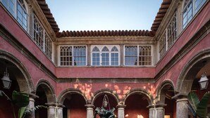 A courtyard with a central fountain, surrounded by arches and columns, and potted plants. - Convento de Cabanas (Viana do Castelo)