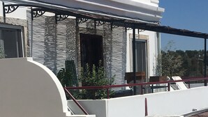 Una escalera que conduce a un edificio de fachada blanca y barandilla metálica.
