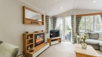Una sala de estar moderna con chimenea, televisor y sofá.