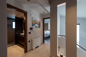 Un bagno moderno con un lavabo in marmo, un termosifone bianco e un quadro appeso al muro.