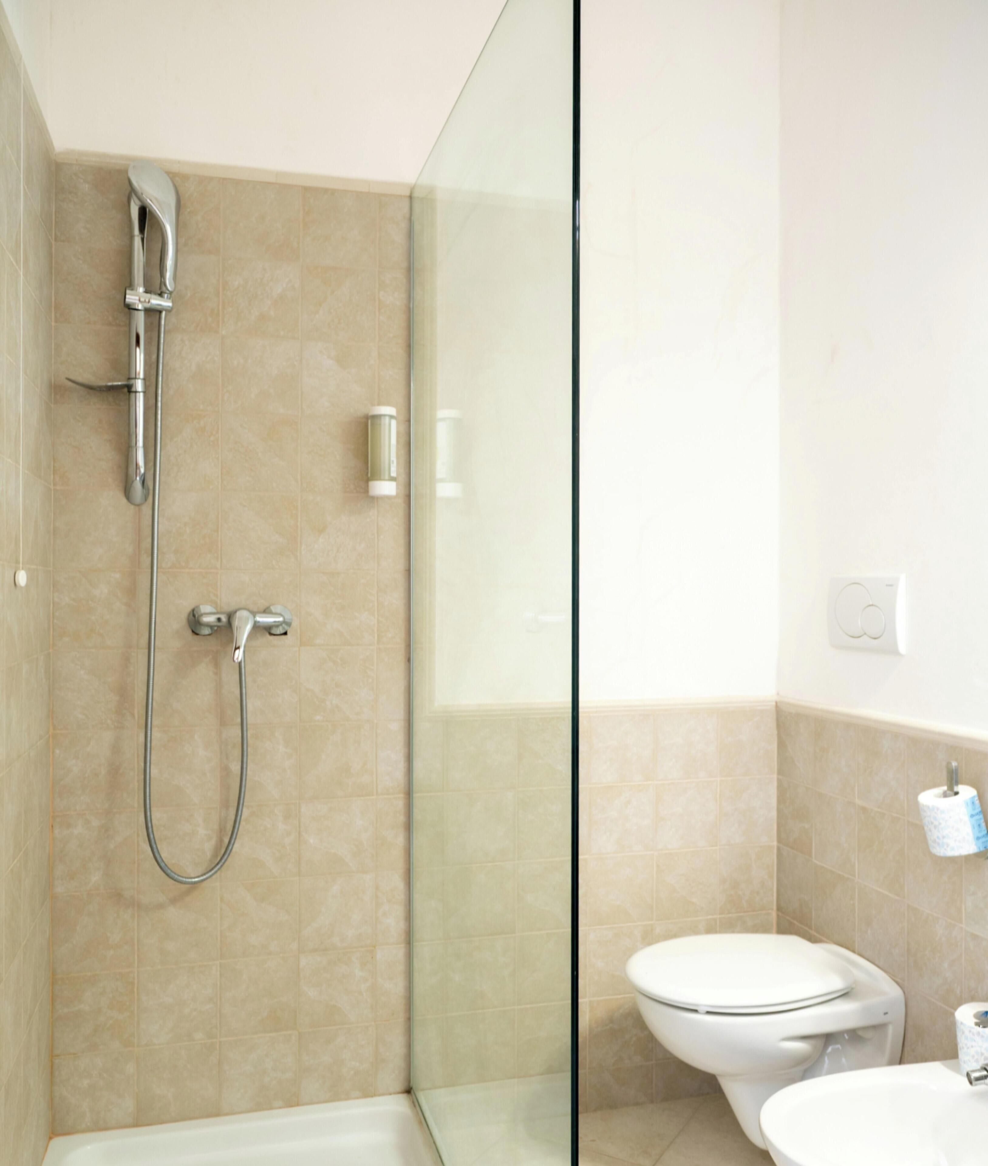 Ein Badezimmer mit Duschkabine, Toilette und Waschbecken.