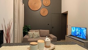 Un soggiorno moderno con divano, televisore e decorazioni a parete.