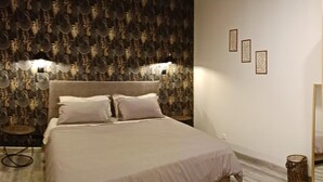 Una camera da letto con un letto, un tavolino rotondo e un pannello decorativo a parete.