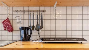 Una cucina con una macchina da caffè, un bollitore e una bilancia digitale sul piano di lavoro.