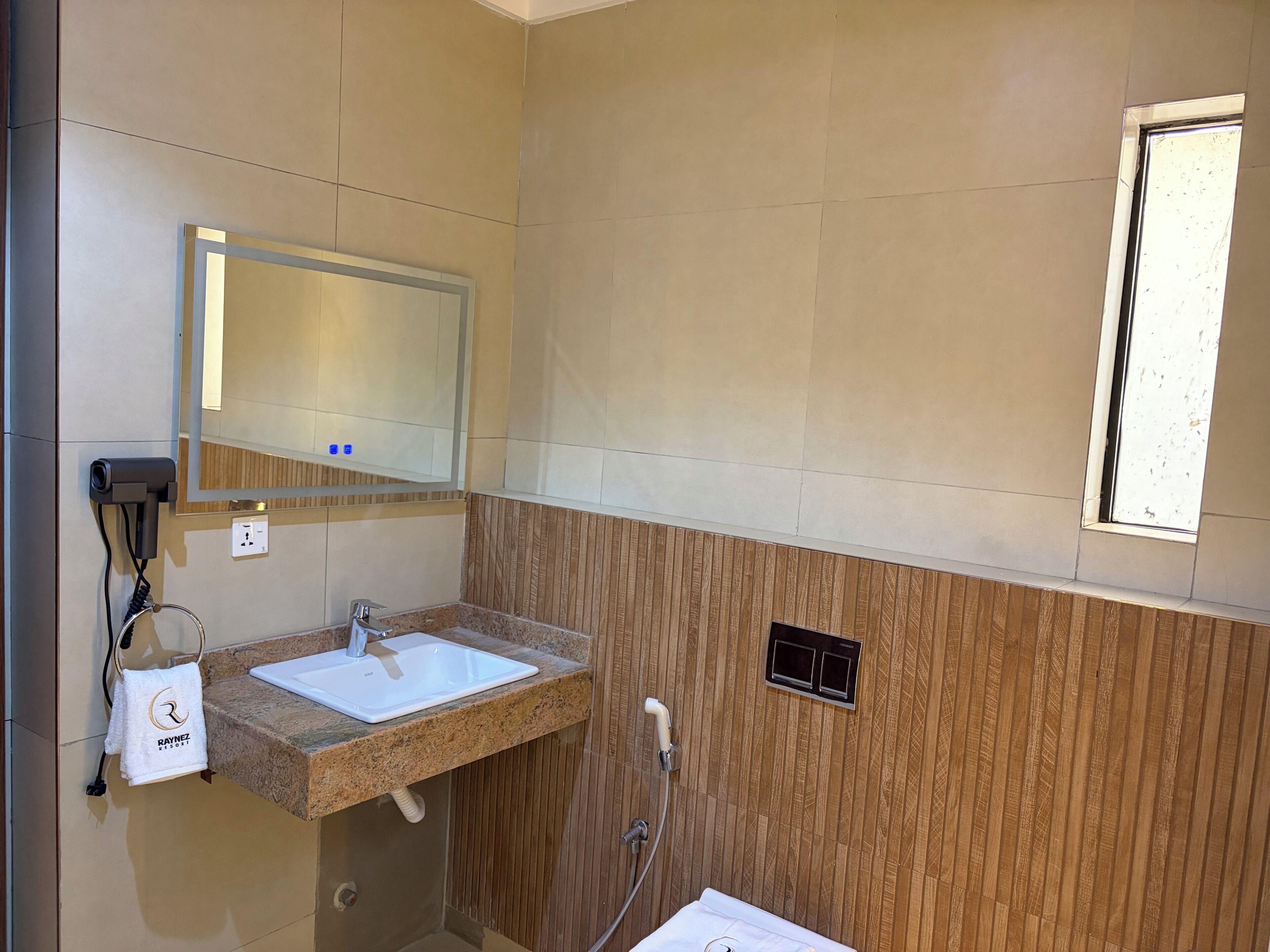 A bathroom with a sink, mirror, and towel rack.