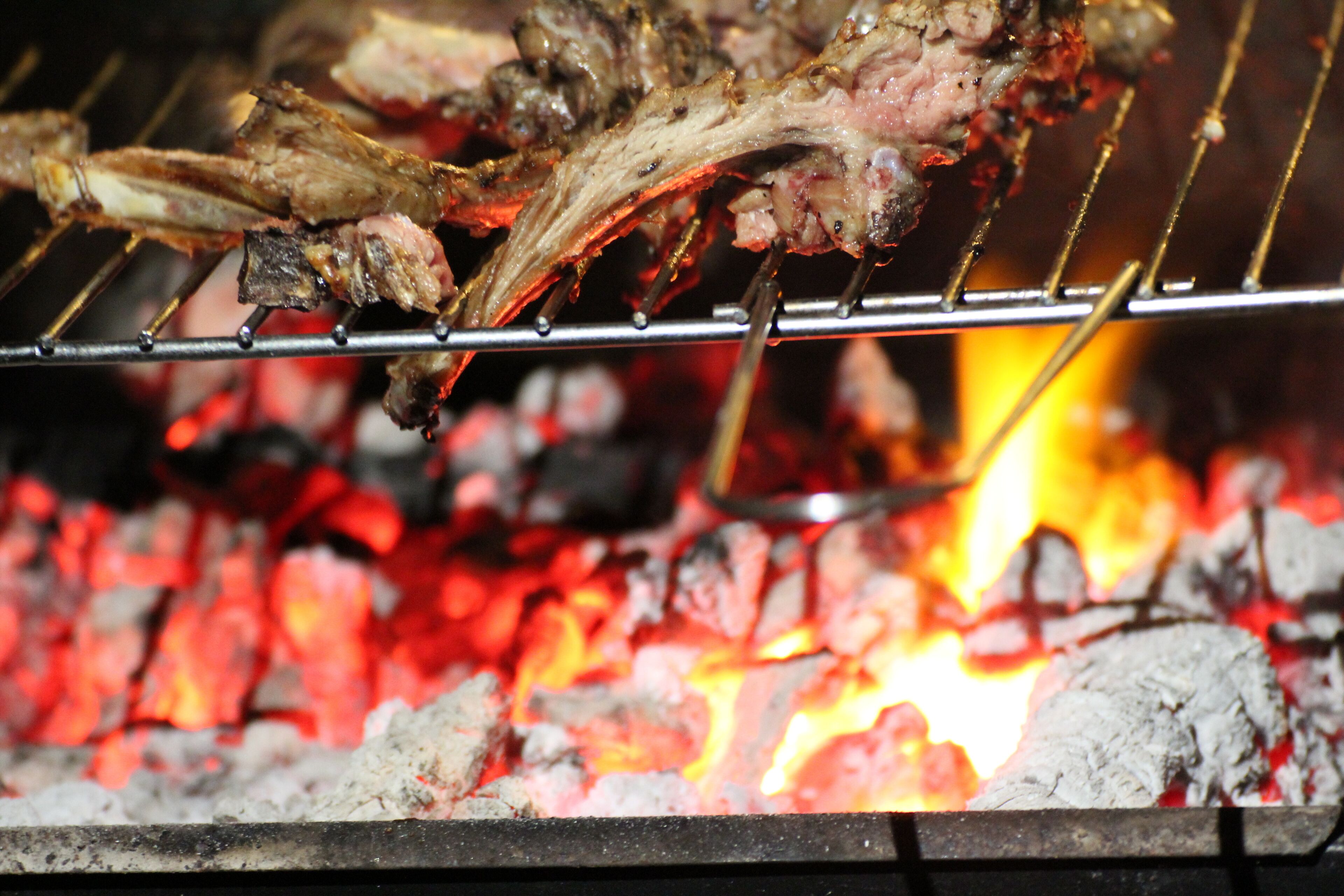 A grill with meat being cooked over an open flame.