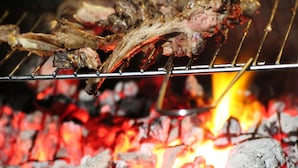 En grill där kött tillagas över öppen eld.