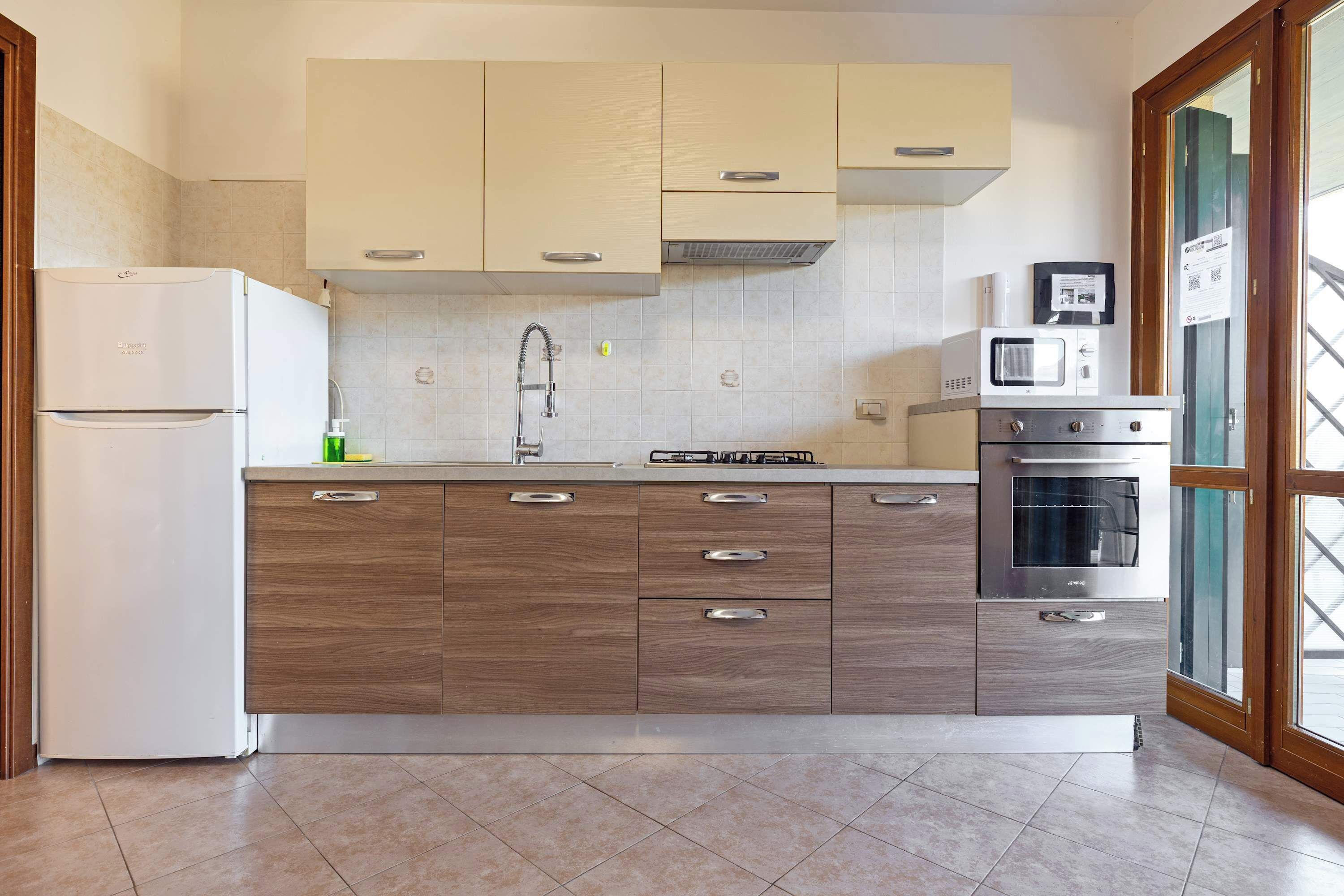 A kitchen with a built-in refrigerator, microwave, stove, and wooden cabinets.