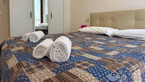 Una habitación de hotel con una cama, un armario y un espejo.