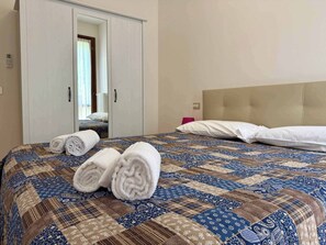 Ein Hotelzimmer mit Bett, Schrank und Spiegel.