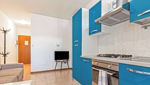 Una cocina moderna con armarios azules, una estufa a gas y un horno empotrado.