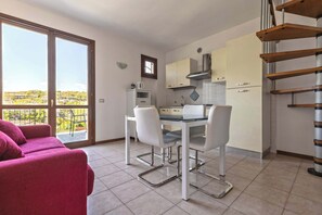 A modern kitchen with a dining area, large windows, and a staircase. - App.17- Le Terrazze del Garda Immobili e Soluzioni (Manerba del Garda)