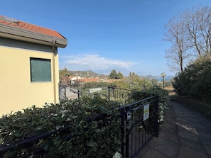 A residential building with a tiled roof, a small window with shutters, and a metal fence. - App.10- Le Terrazze del Garda Immobili e Soluzioni (Manerba del Garda)