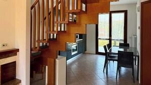 A staircase with wooden railings leading to a dining area with a table and chairs. - App.11- Le Terrazze del Garda Immobili e Soluzioni (Manerba del Garda)