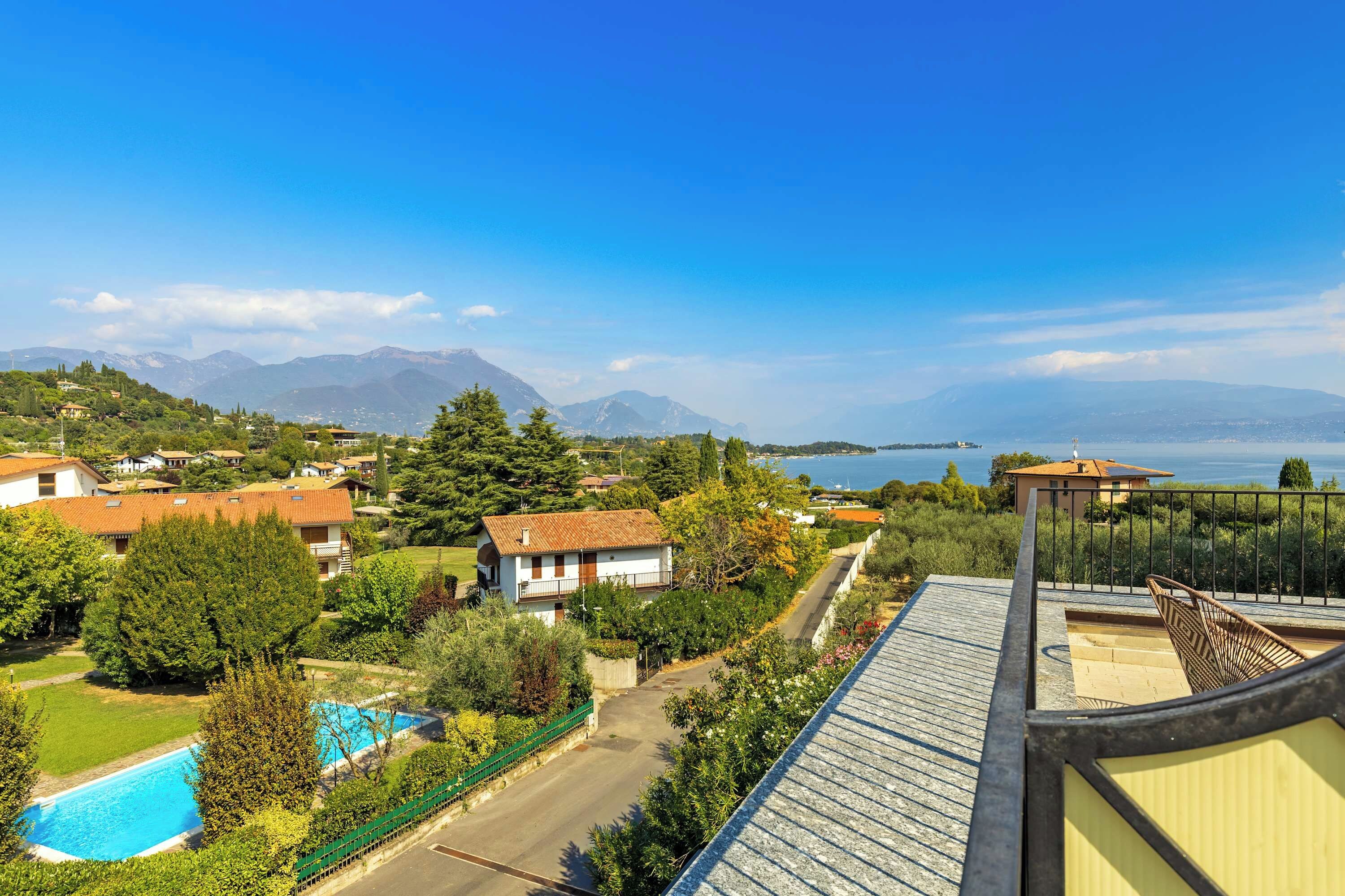 Un barrio residencial con casas, una piscina y vistas al mar y a las montañas.