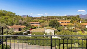 A residential area with multiple houses, a clear sky, and mountains in the background. - App.14- Le Terrazze del Garda Immobili e Soluzioni (Manerba del Garda)