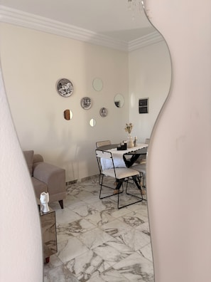 A dining area with a table, chairs, and a sofa. - Cosy little apartment a stone's throw from the sea (Hammamet)