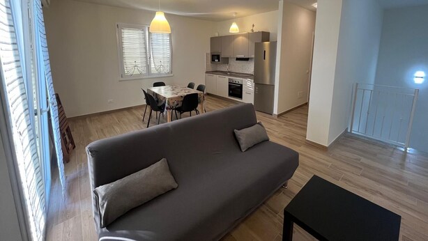 Um apartamento moderno com sala de estar, área de jantar e cozinha.