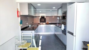 A modern kitchen with a central island, stainless steel appliances, and a glass door oven.