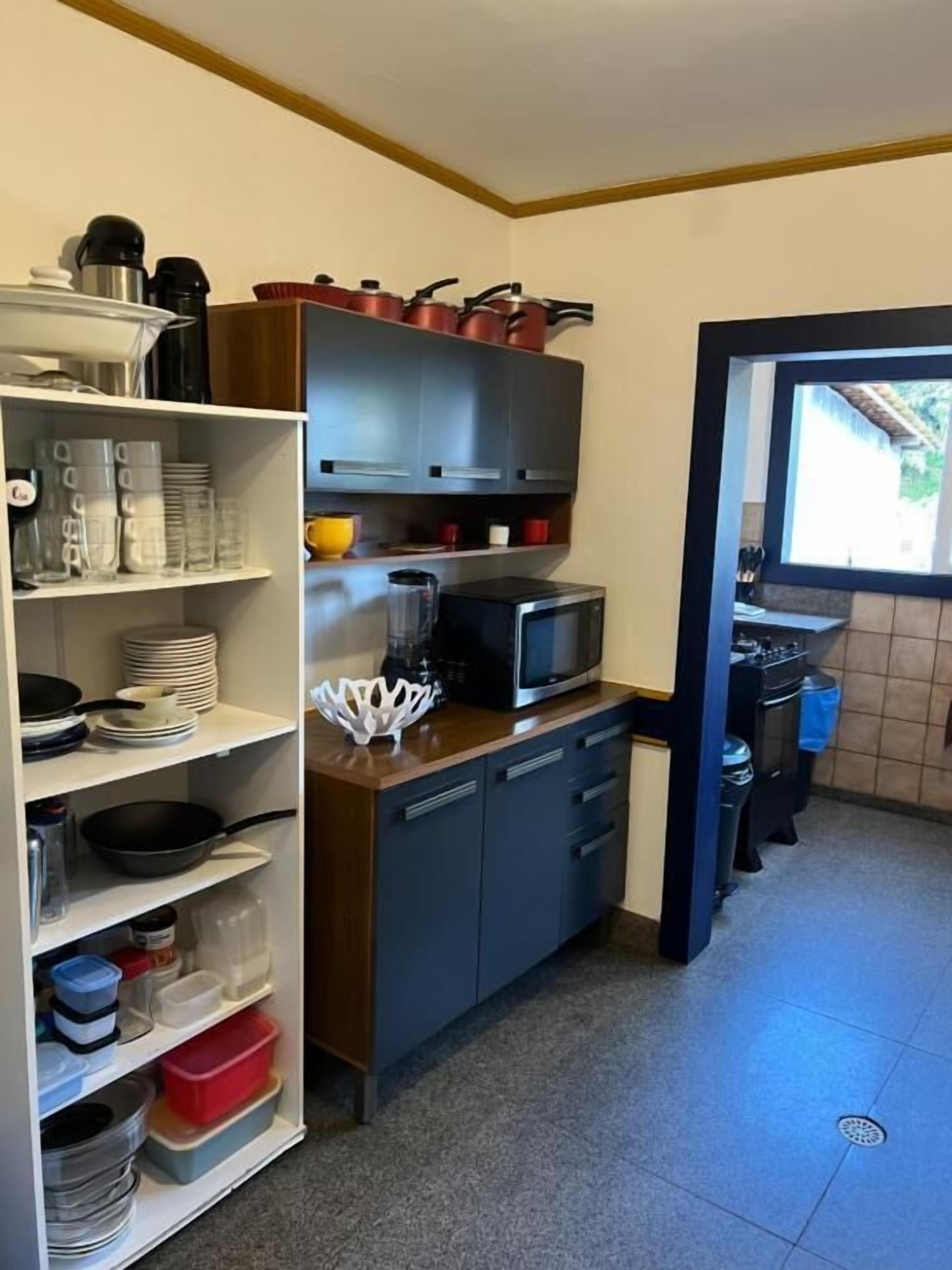 Una cocina compacta con microondas, armarios de almacenamiento y una ventana.