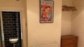 A bathroom with a black tiled wall, a white sink, a radiator, and a wooden cabinet. - 3 Bed Sleeps 6 Free Parking Enclosed Garden (Tonbridge)