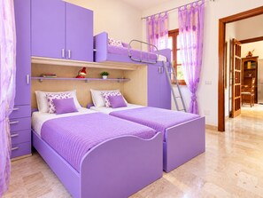 A bedroom with two beds, a wardrobe, a shelf with books, a desk, and a chair. - Capo Comino 1 - Two Bedroom Apartment, Sleeps 5 (La Caletta)