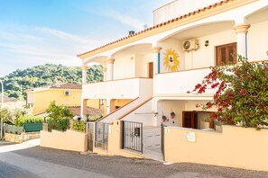 A two-story building with a balcony, a staircase, and a gate. - Bouganville - Two Bedroom Apartment, Sleeps 4 (Posada)
