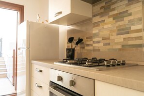 A kitchen with a stove, oven, and cabinets. - Bouganville - Two Bedroom Apartment, Sleeps 4 (Posada)