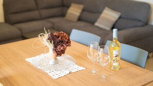 A dining table with a bottle of wine, two glasses, and a decorative centerpiece. - Berchida 6 - Two Bedroom Apartment, Sleeps 5 (La Caletta)