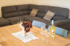 A dining table with a bottle of wine, two glasses, and a decorative centerpiece. - Berchida 6 - Two Bedroom Apartment, Sleeps 5 (La Caletta)