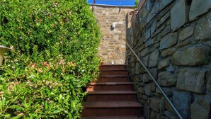 Un escalier en pierre dont les marches mènent à une rambarde bleue.