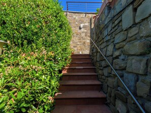A stone staircase with steps leading up to a blue railing. - Montparnasse by Interhome (Punta Ala)
