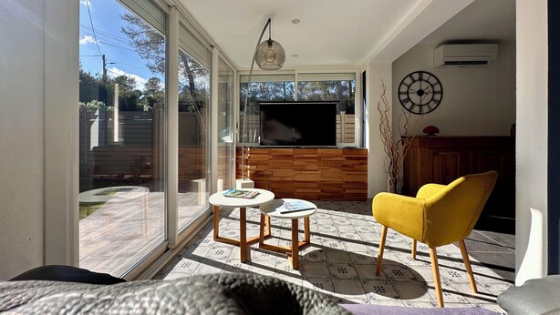 Una sala de estar moderna con televisor, sillón amarillo y chimenea.