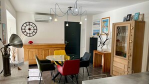 Una cocina moderna con comedor, que incluye una mesa redonda, sillas coloridas, un armario de madera y una escultura decorativa de asta.