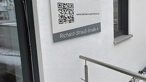 Segnale per Balisana Apartments, con un codice QR e l'indirizzo.