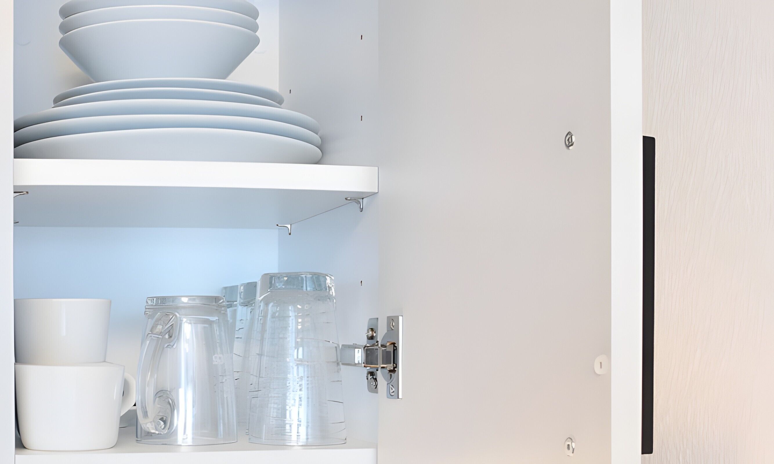 A kitchen with white cabinets, a hanging pot rack, and various kitchenware.