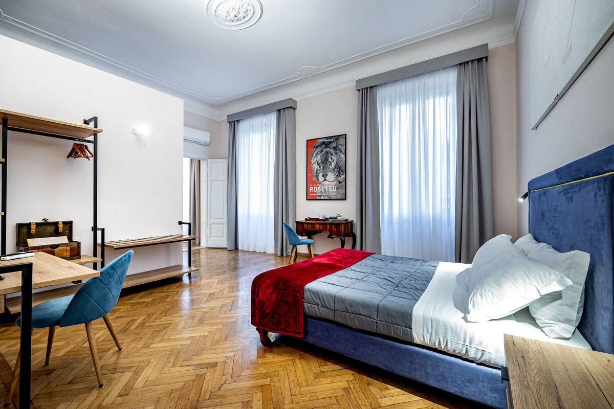A bedroom with a bed, a desk, a chair, and a wardrobe.