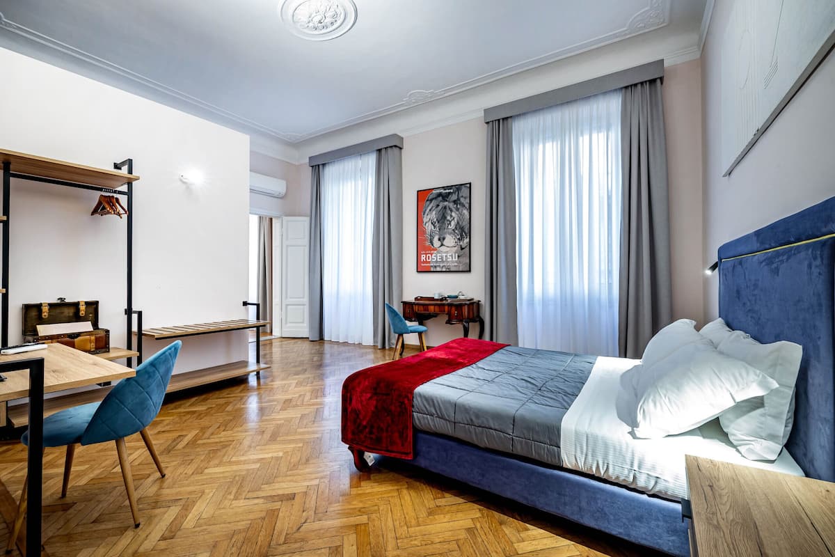 Ein Schlafzimmer mit Bett, Schreibtisch, Stuhl und Kleiderschrank.