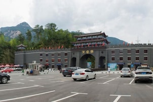 Un edificio de estilo arquitectónico tradicional, un estacionamiento y un paisaje montañoso de fondo.