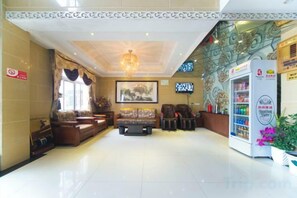 A hotel lobby with a reception desk, seating area, and a vending machine. - Junyi Nanshan Hotel, Luotian (Luotian County)