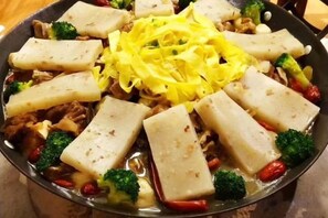 A dish with tofu, broccoli, and red peppers in a pan. - Junyi Nanshan Hotel, Luotian (Luotian County)