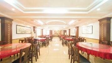 A spacious dining area with multiple tables and chairs, arranged in rows.