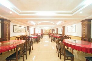 Un comedor amplio con varias mesas y sillas, dispuestas en filas.