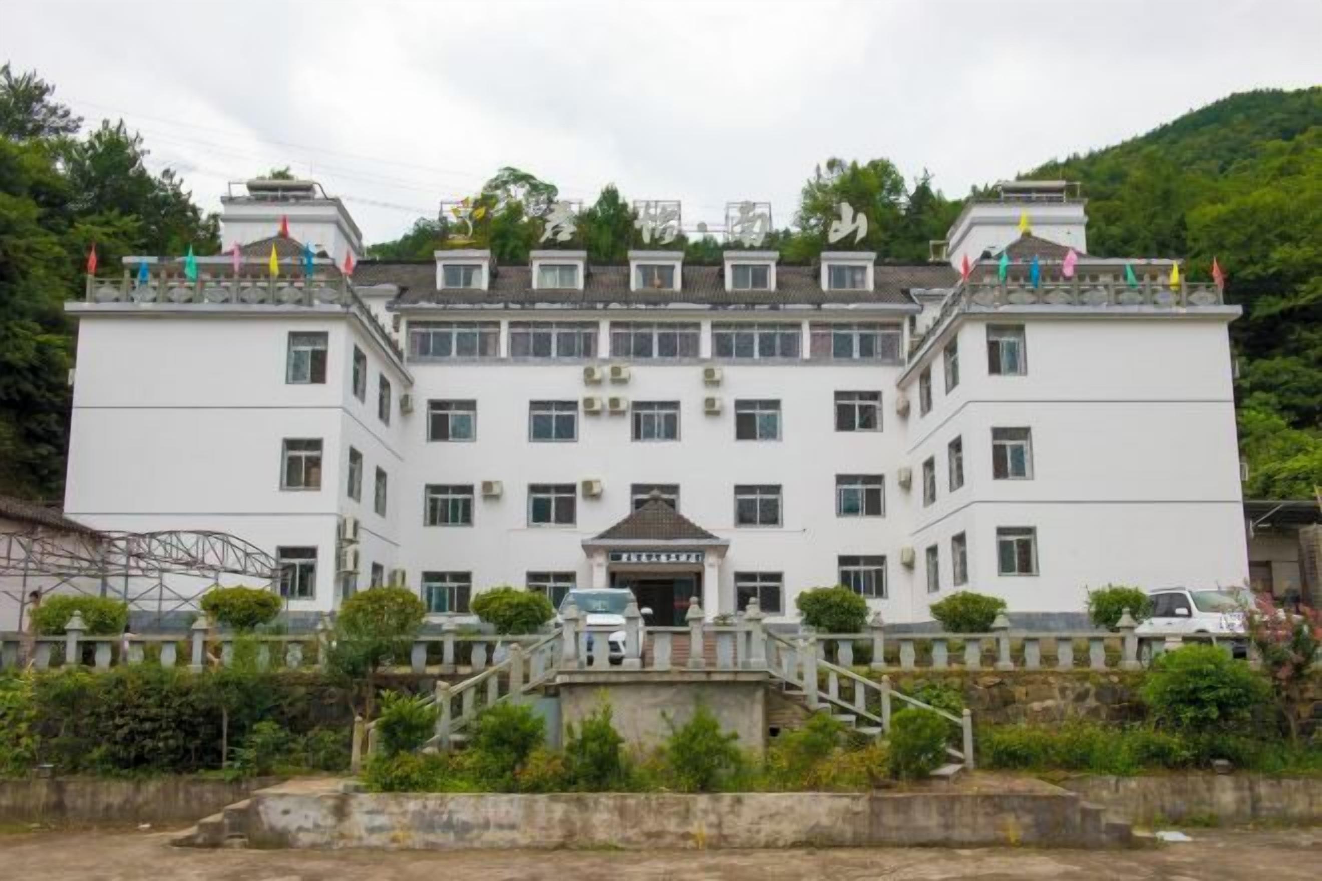 A large, multi-story building with a symmetrical facade, a central entrance, and a staircase leading to a balcony.