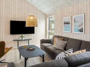 A modern living room with a flat-screen TV, a round coffee table, a sofa set, and a decorative lamp. - 5 Star Holiday Home in Idestrup (Idestrup)