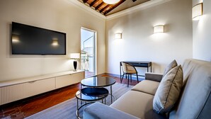 Un salon moderne avec un téléviseur à écran plat, un canapé, une table basse et une cheminée.