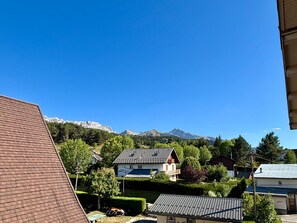 Ein Wohngebiet mit Häusern, blauem Himmel und Bergen im Hintergrund.