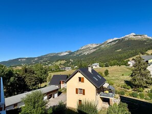A residential area with houses, a mountain backdrop, and a clear sky. - Cozy 2-room apartment near ski slopes (Villard-de-Lans)