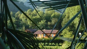 Uma casa rodeada por vegetação exuberante e colinas.