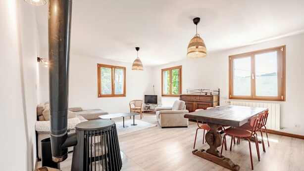 A spacious living area with a sofa, a dining table with chairs, a TV, and a fireplace. - For large gatherings: 2 apartments under a welcoming roof (Taninges)